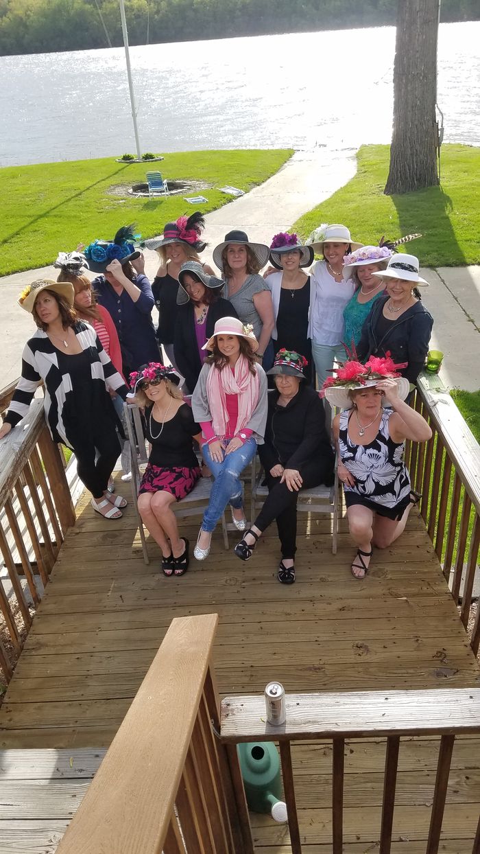 Members in Derby hats gathered on the deck above the river