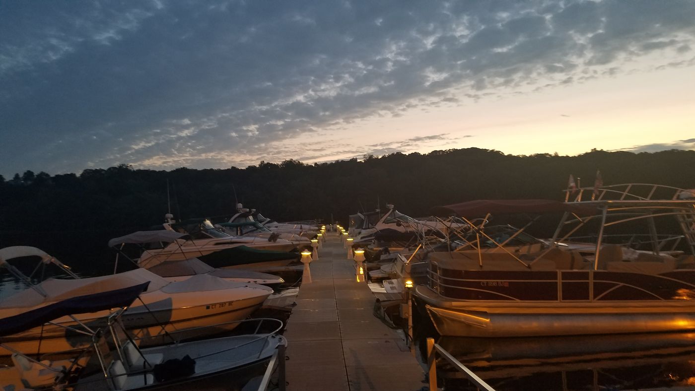 Club docks lit up at dusk with boats tied alongside