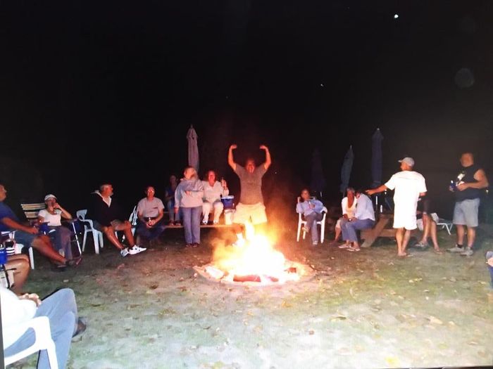 Members gathered around the fire pit at night