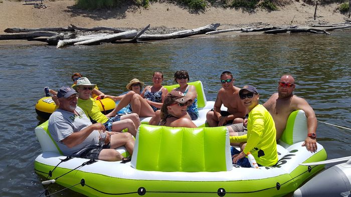 Members relaxing on a big inflatable float on the river